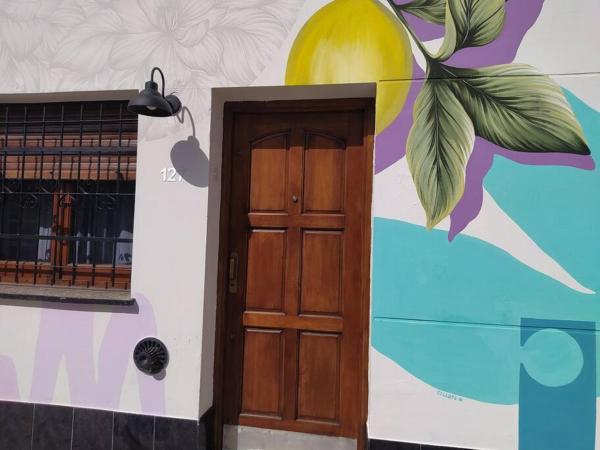una puerta frente a una pared con un mural en Casa Limón en Chascomús