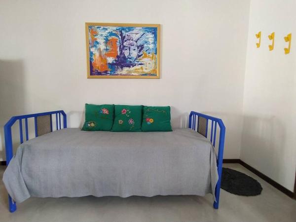 1 cama con almohadas verdes y una pintura en la pared en Casa Limón en Chascomús