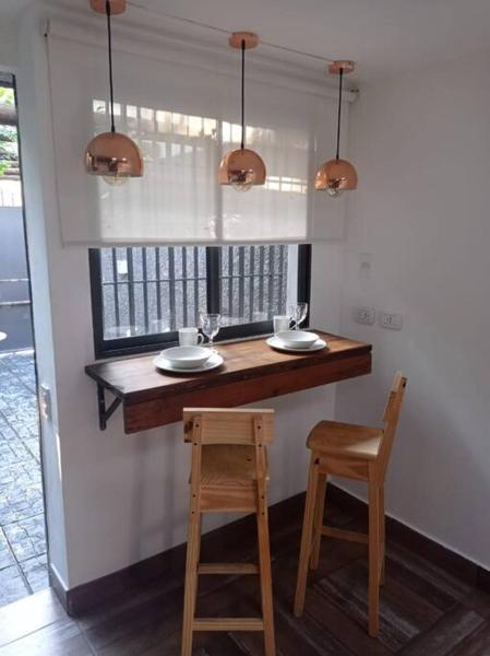 un bar con 2 sillas, una mesa y dos luces en Estudio RUFINA IV en el corazón de Mendoza, en Mendoza
