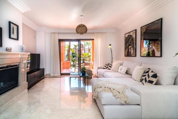 sala de estar con sofá blanco y chimenea en Solvasari, en Marbella