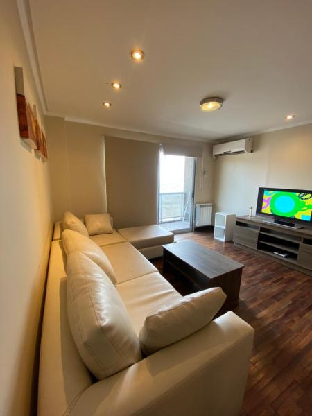 sala de estar con sofá y TV en Departamento Lindo Colonial Salta en Salta
