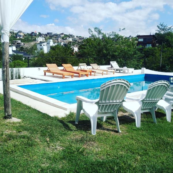 un grupo de sillas sentadas junto a una piscina en SIMION en Villa Carlos Paz