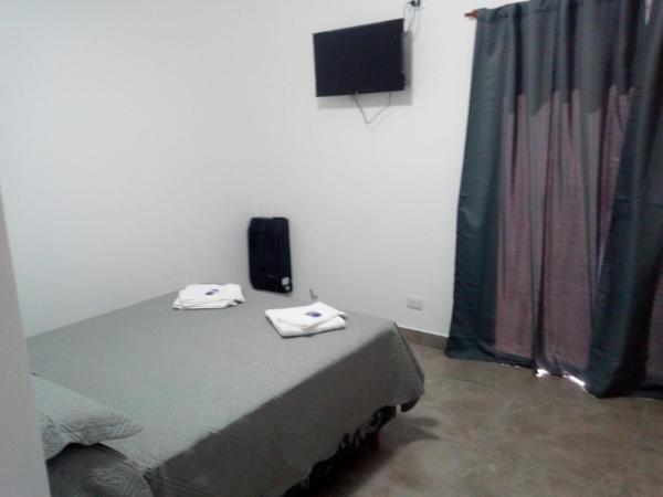 1 dormitorio con 1 cama con 2 toallas en Departamento Ezeiza- ciudad de Tandil en Tandil