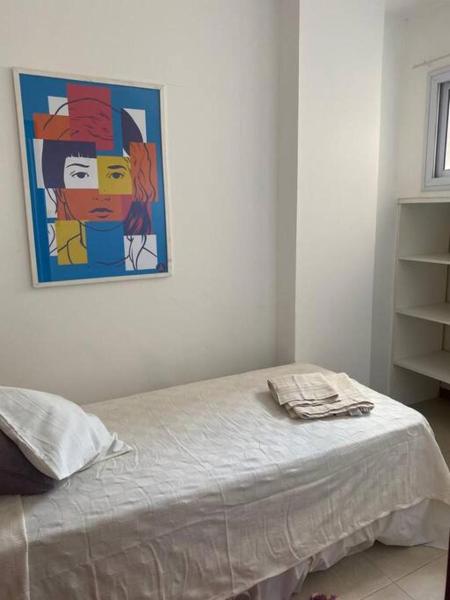 1 dormitorio con 1 cama con una pintura en la pared en Departamento tranquilo completamente equipado en Salta