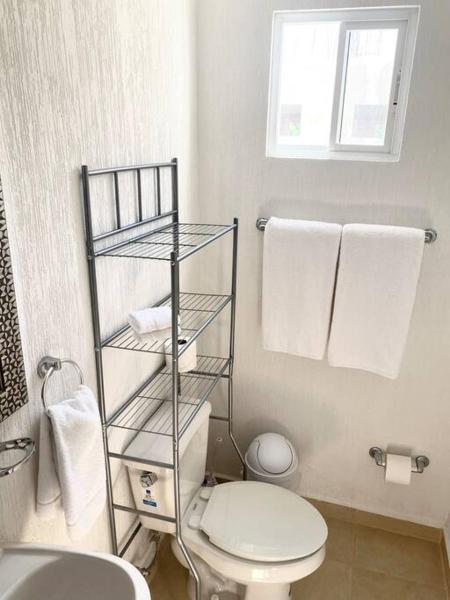 y baño con aseo blanco y toallas. en House in Frontemare by Los Olivos 134, en Playa del Carmen