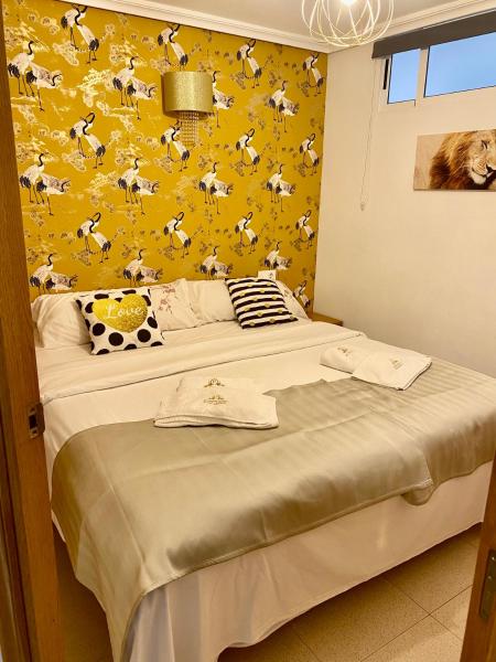 1 dormitorio con 1 cama con pared amarilla en MY SUNNY PAYMA BEACH Apartment, en Benidorm