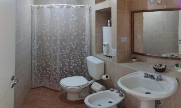 y baño con aseo, lavabo y ducha. en Dpto planta alta La Mendoza en San Miguel de Tucumán