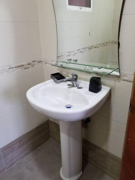 lavabo blanco en baño con espejo en COZY AND LOVELY APARTMENT, en Santo Domingo