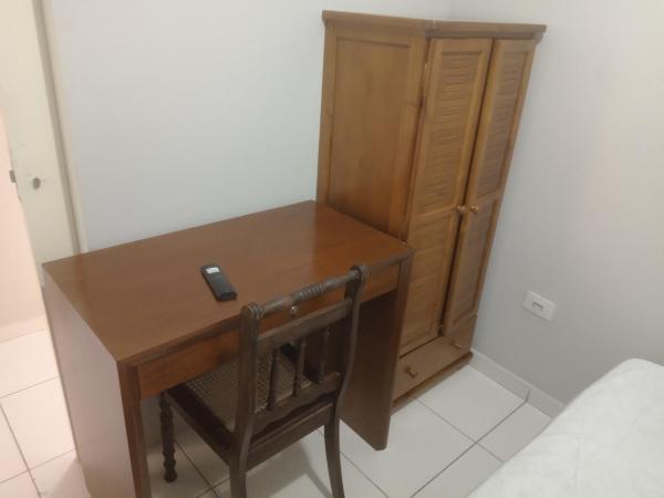 un escritorio de madera con una silla junto a un armario en Quarto no Brooklin SP, en São Paulo