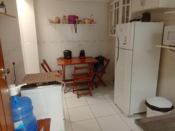 cocina con mesa y refrigerador blanca en Quarto no Brooklin SP, en São Paulo