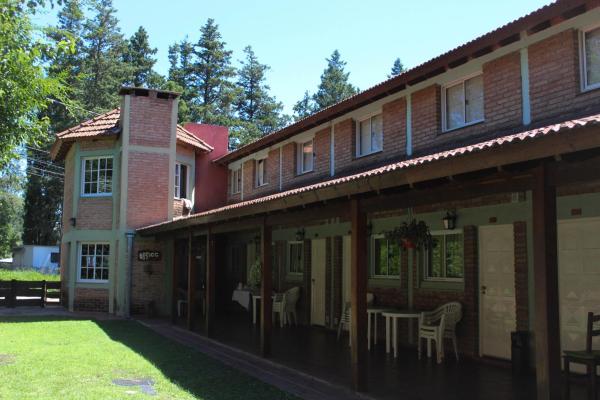 un edificio con una mesa y sillas en un patio en La Palapa ApartHotel en Villa General Belgrano