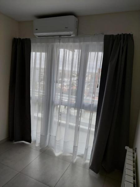 una ventana con cortinas blancas en una habitación en Directo al Mar Suite en Puerto Madryn