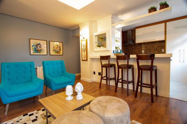 sala de estar con bar y sillas azules en Waldhaus 303 - My Home Temporada, en Gramado