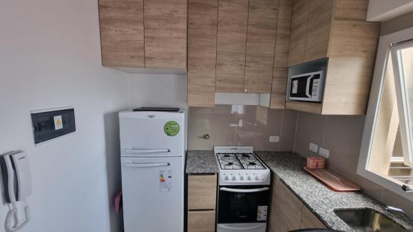 cocina pequeña con refrigerador y fogones en Hermoso departamento, excelente ubicación. en Salta