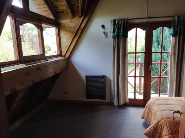 1 dormitorio con 2 ventanas y 1 cama. en Habitacion privada en cabaña compartida "Los Cordobeses" en San Martín de los Andes
