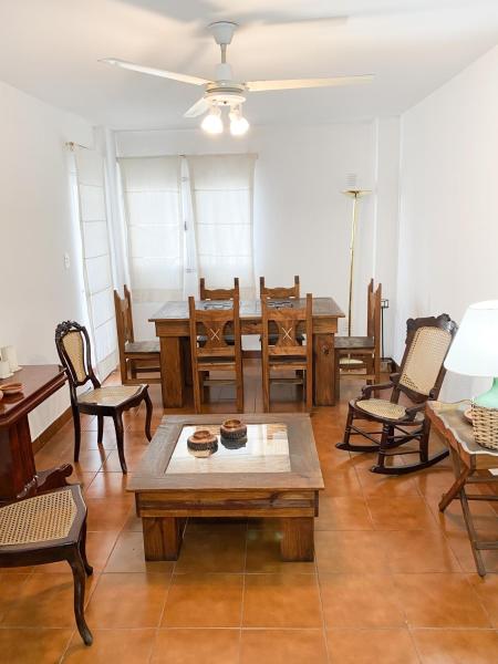 una sala de estar con mesas y sillas de madera. en Departamento con estilo salteño en Salta