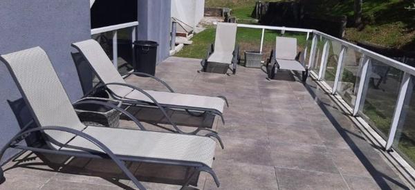una fila de sillas sentadas en un balcón en el Departamento Apart Espai Marina en Villa Gesell