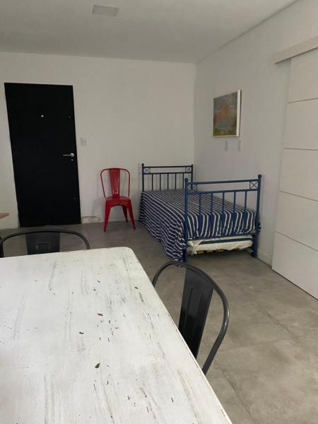 Habitación con mesa, sillas y cama en Village en Tandil