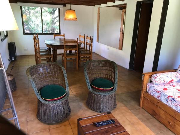 un salón con un sofá y sillas y una mesa en la Casa Jardín - Barrio Norte de Villa Gesell