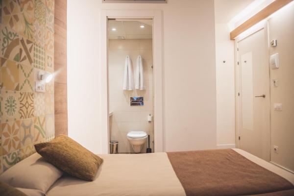 Dormitorio pequeño con cama y aseo en Hostal Marenostrum, en Barcelona