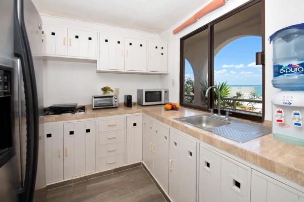 cocina con fregadero y ventana grande en Cozy Penthouse apartment with ocean view, en Cancún