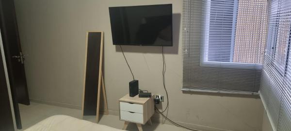 Habitación con TV en la pared y cama en Edificio quinta sur 3 en Mendoza