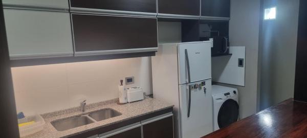 una pequeña cocina con fregadero y refrigerador. en Edificio quinta sur 3 en Mendoza