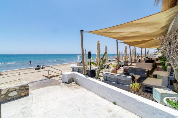 una playa con sombrillas y sillas y el océano en Stay U-nique Apartments Alvarito Playa, en Marbella