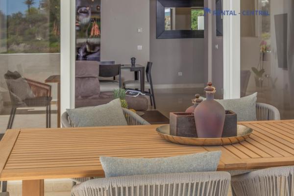 una mesa de madera con sillas y un jarrón.  en Stunning Views 3 Bedroom Luxury Flat with Pool, en Marbella