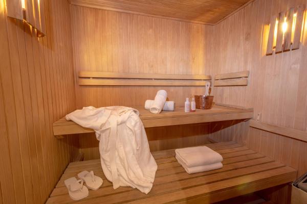 una sauna con una estantería de madera y toallas. en Runa Moraira Apart & Spa en Mar de las Pampas