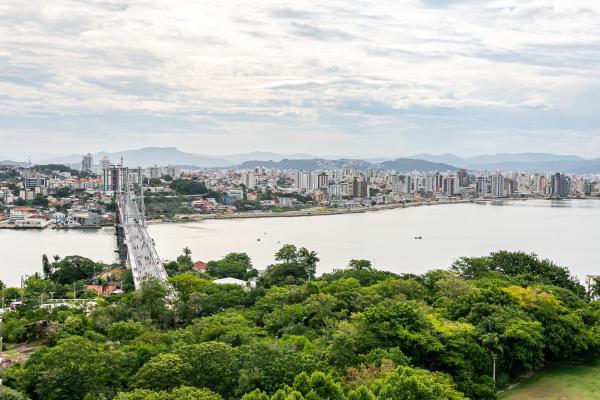 a bridge over a river with a city in the background at Apto 2 quartos deslumbrante com piscina - Centro in Florianópolis