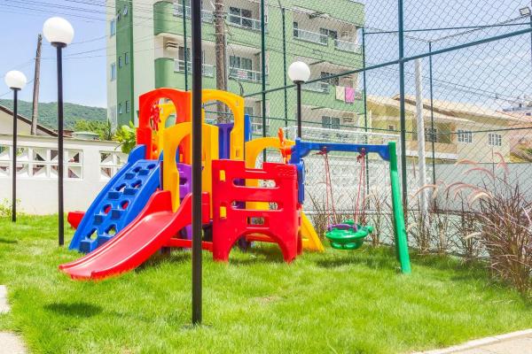 un parque infantil con toboganes coloridos en el césped en Terrazzo Club Residence 407-B - Apartamento em Bombas - Edifício com Jacuzzi - Piscina - Quadra Poliesportiva, en Bombinhas