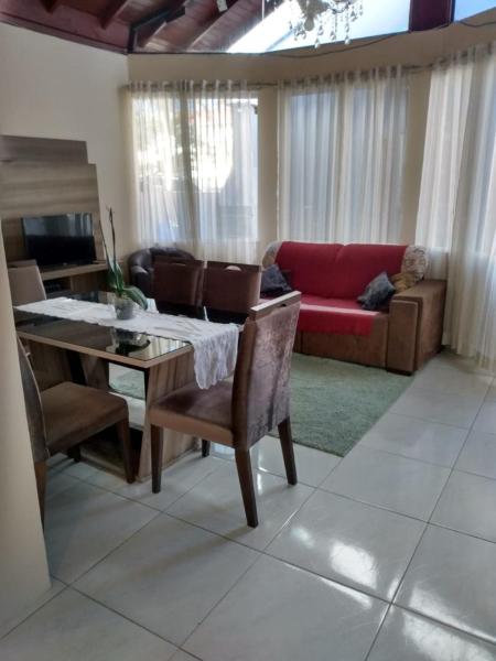 a living room with a table and a red couch at Casa na Praia de Ingleses in Florianópolis