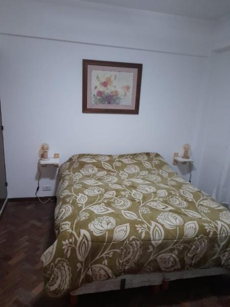 Una cama en un dormitorio con una manta. en Lo de Marta en Salta