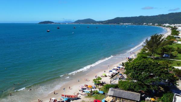 an aerial view of a beach with people and the ocean at Regina del mare apartamento de 02 dormitorios para até 06 pessoas a 50 mts da praia in Florianópolis