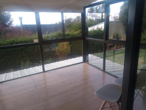 Habitación con vistas al jardín y vistas a través de cristal.  en Chalet Céntrico en Barrio Residencial en San Carlos de Bariloche