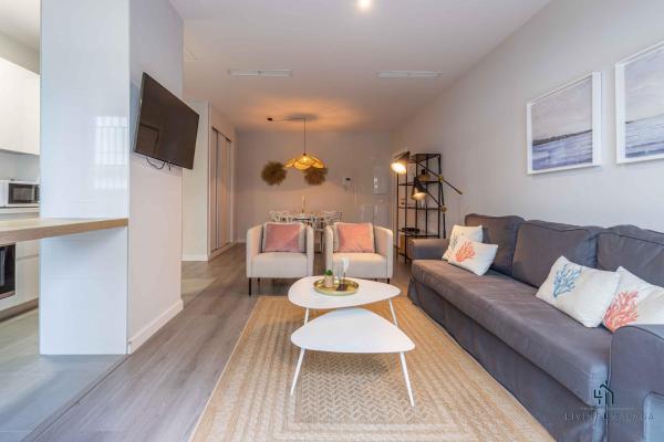 sala de estar con sofá y mesa en Living4Malaga Pacific Terrace Apartment, en Málaga