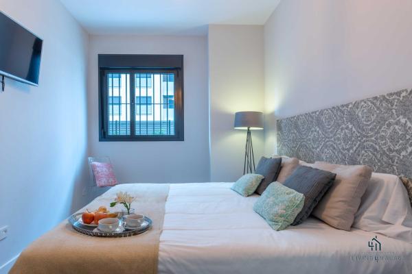 Un dormitorio con una cama con una bandeja de fruta. en Living4Malaga Pacific Terrace Apartment, en Málaga