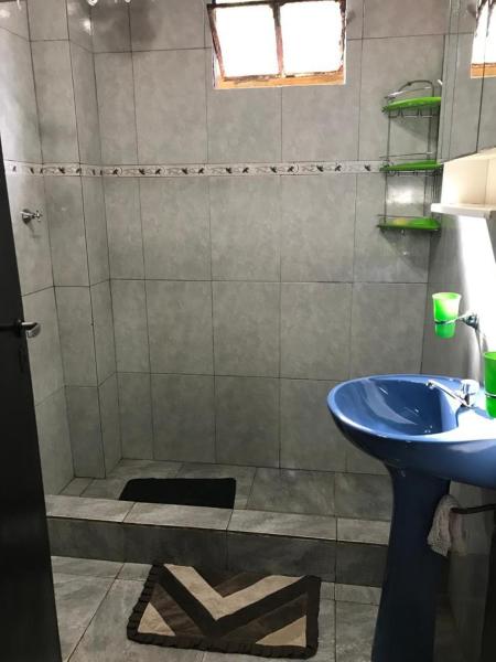 y baño con lavabo azul y ducha. en Yate I en Puerto Iguazú