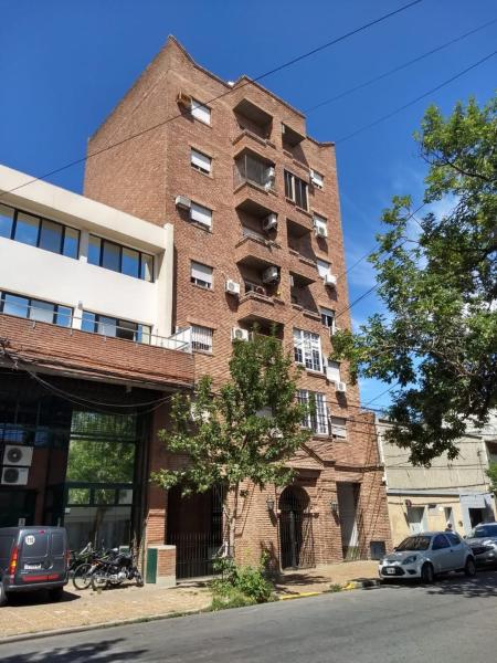 a tall brick building with cars parked in front of it at Departamento CM in Santa Fe
