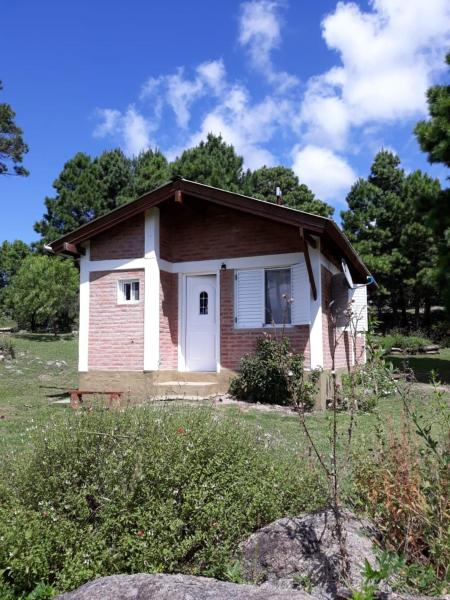 una pequeña casa de ladrillo con una puerta blanca en Espejo de Hadas - Terrafirme, en Villa Yacanto