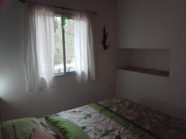 1 dormitorio con cama y ventana en Espejo de Hadas - Terrafirme, en Villa Yacanto
