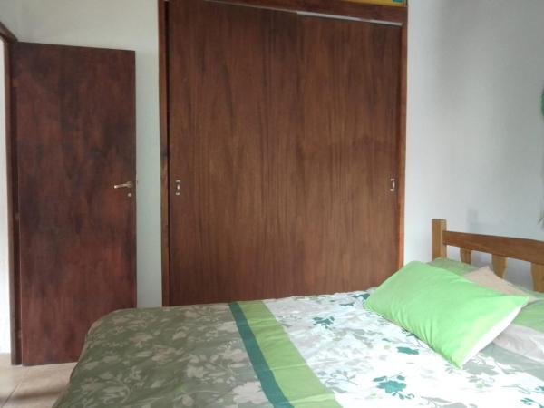 1 dormitorio con 1 cama y puerta de madera en Espejo de Hadas - Terrafirme, en Villa Yacanto
