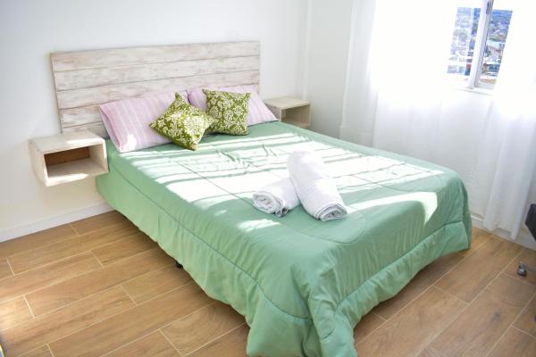 1 dormitorio con 1 cama grande y 2 almohadas en la mas linda ventana al mar en Puerto Madryn