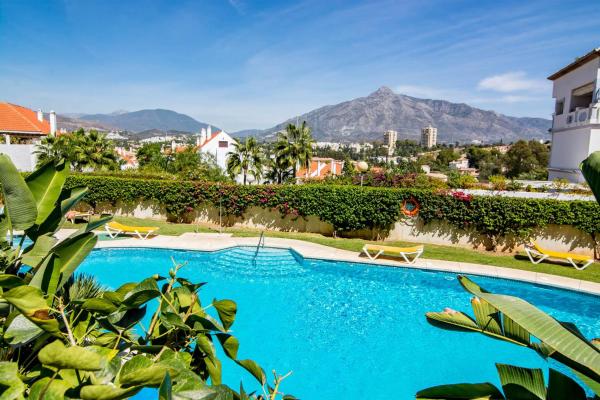 una piscina en un complejo con montañas en el fondo en SAT1-walking distance to Puerto Banus, en Marbella