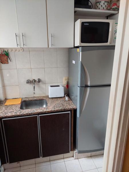cocina con refrigerador de acero inoxidable y microondas en Hermoso depto con vista al mar en Mar del Plata