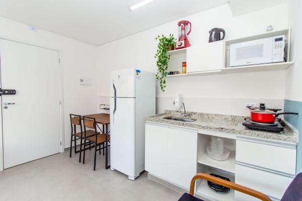 cocina con refrigerador blanca y mesa en 360 Suítes San Fran - Apartamentos mobiliados, en São Paulo