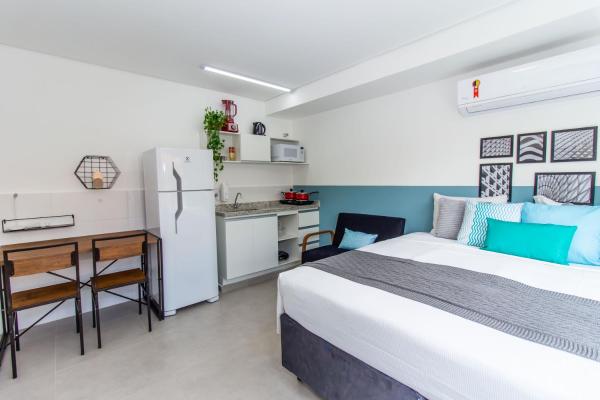 1 dormitorio con 1 cama y cocina con refrigerador en 360 Suítes San Fran - Apartamentos mobiliados, en São Paulo