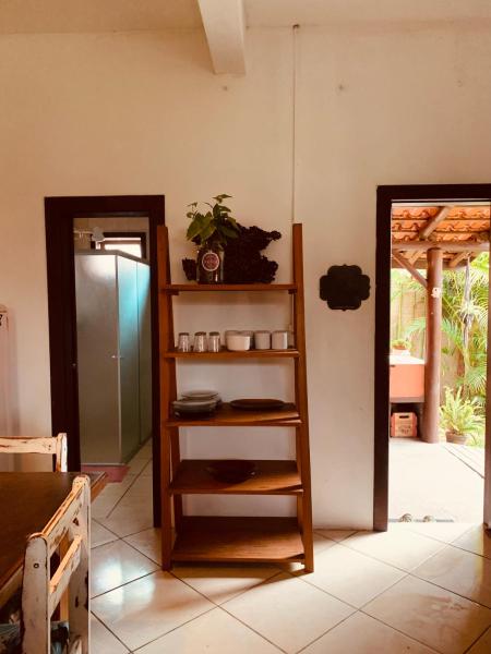 a kitchen with a shelf and a refrigerator at Boa Vibe Complexo Rosa Norte in Praia do Rosa