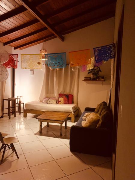 a bedroom with a bed and a couch in a room at Boa Vibe Complexo Rosa Norte in Praia do Rosa